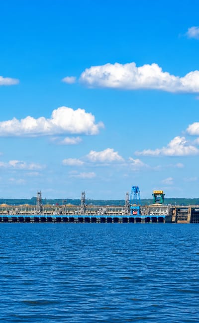 Hydroelectric dam stretching across the Dnipro reservoir near Kamianske, Ukraine, under a blue sky