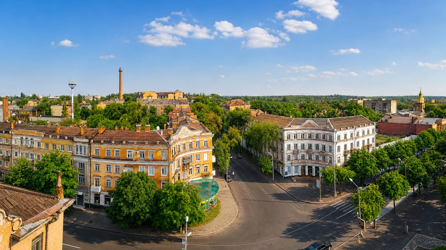 Aerial of a tree-lined square with historic buildings and a factory chimney in Kryvyy Rih, Ukraine