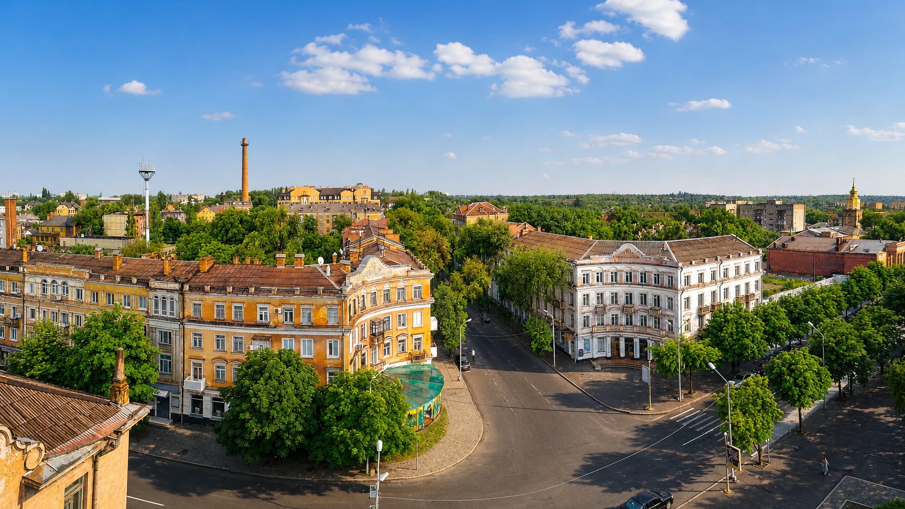 Aerial of a tree-lined square with historic buildings and a factory chimney in Kryvyy Rih, Ukraine