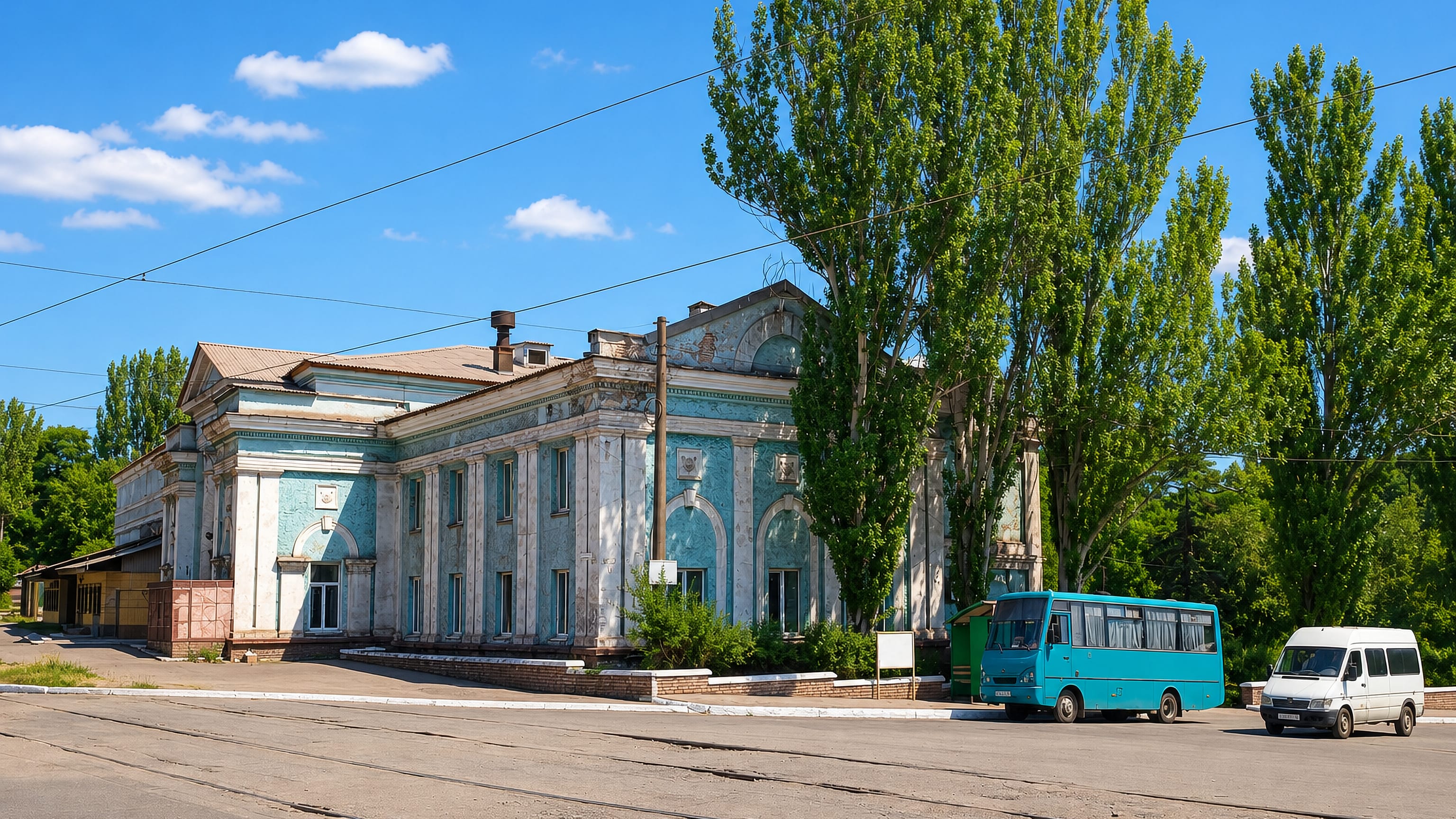Weathered Stalinist-era columned palace of culture on a tram-tracked square in Yenakiieve, eastern Ukraine.