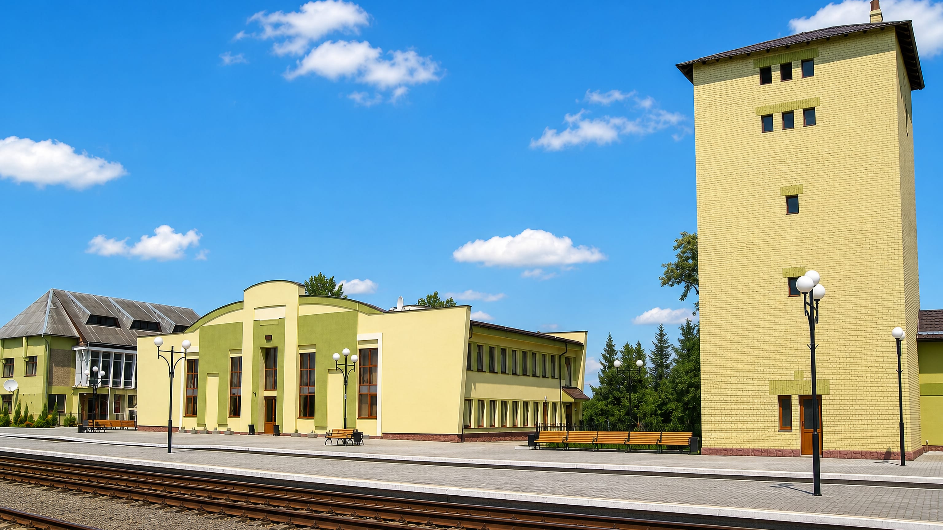 Kalush railway station in western Ukraine, its yellow-brick tower and platform seen across the tracks.