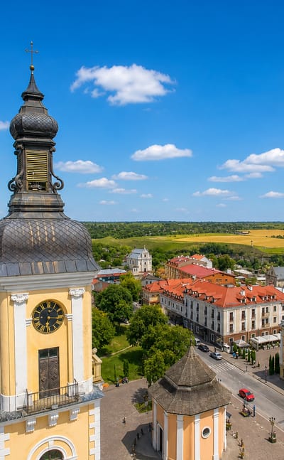 Aerial view of Kamianets-Podilskyi, Ukraine, with the old town's yellow bell tower and the fortress beyond red roofs