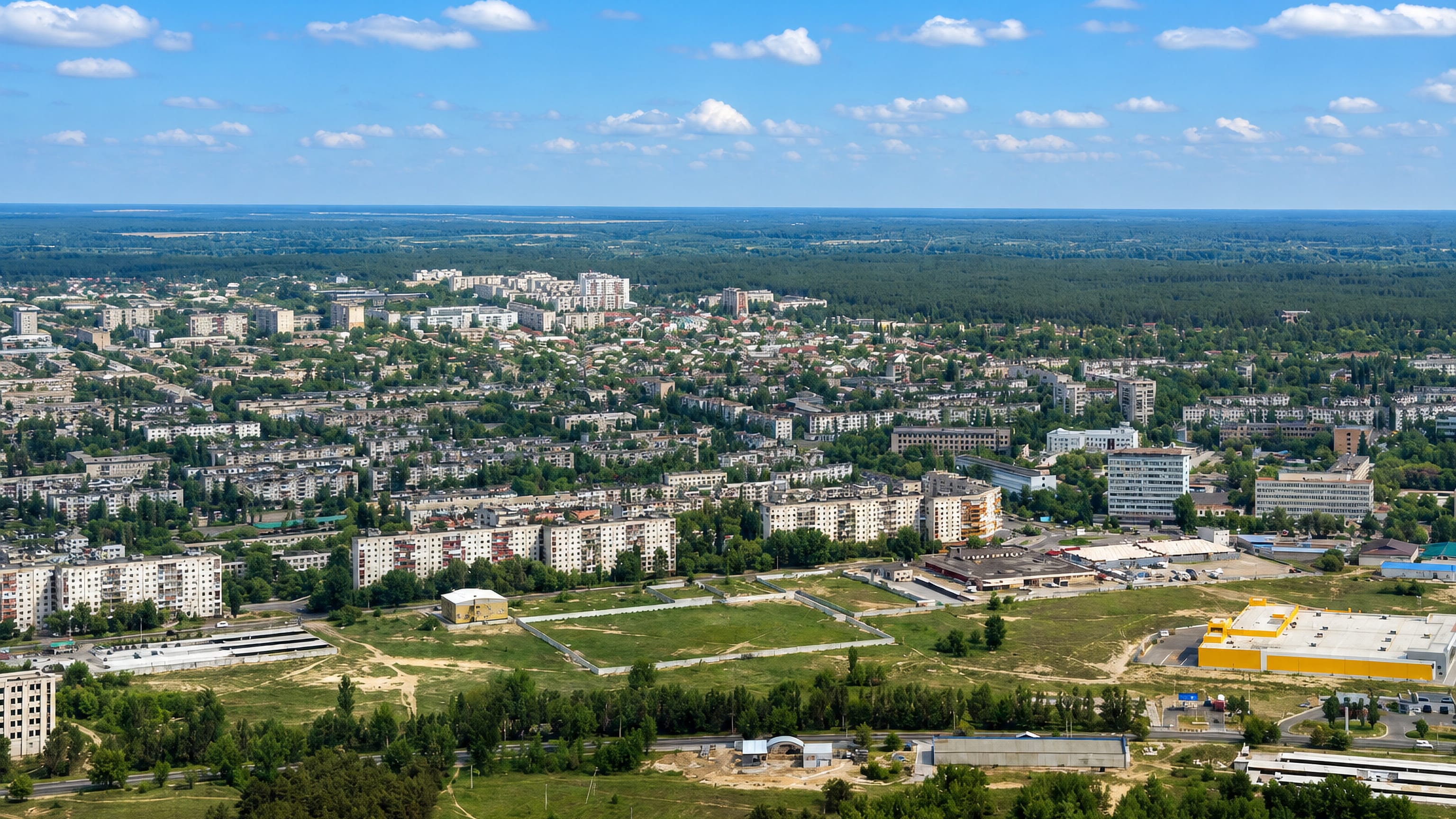 Aerial view of Siverskodonetsk, Ukraine, its apartment blocks and low-rise streets ringed by pine forest.