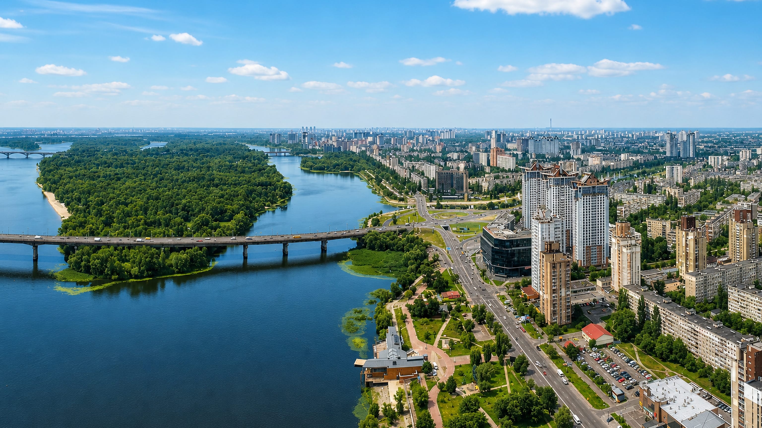 Aerial view of the Dnipro riverfront, bridge and high-rise blocks of Berezniaky on Kyiv's left bank.