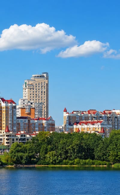 Obolon riverside skyline in Kyiv with a golden-domed church and pastel high-rises along the Dnieper