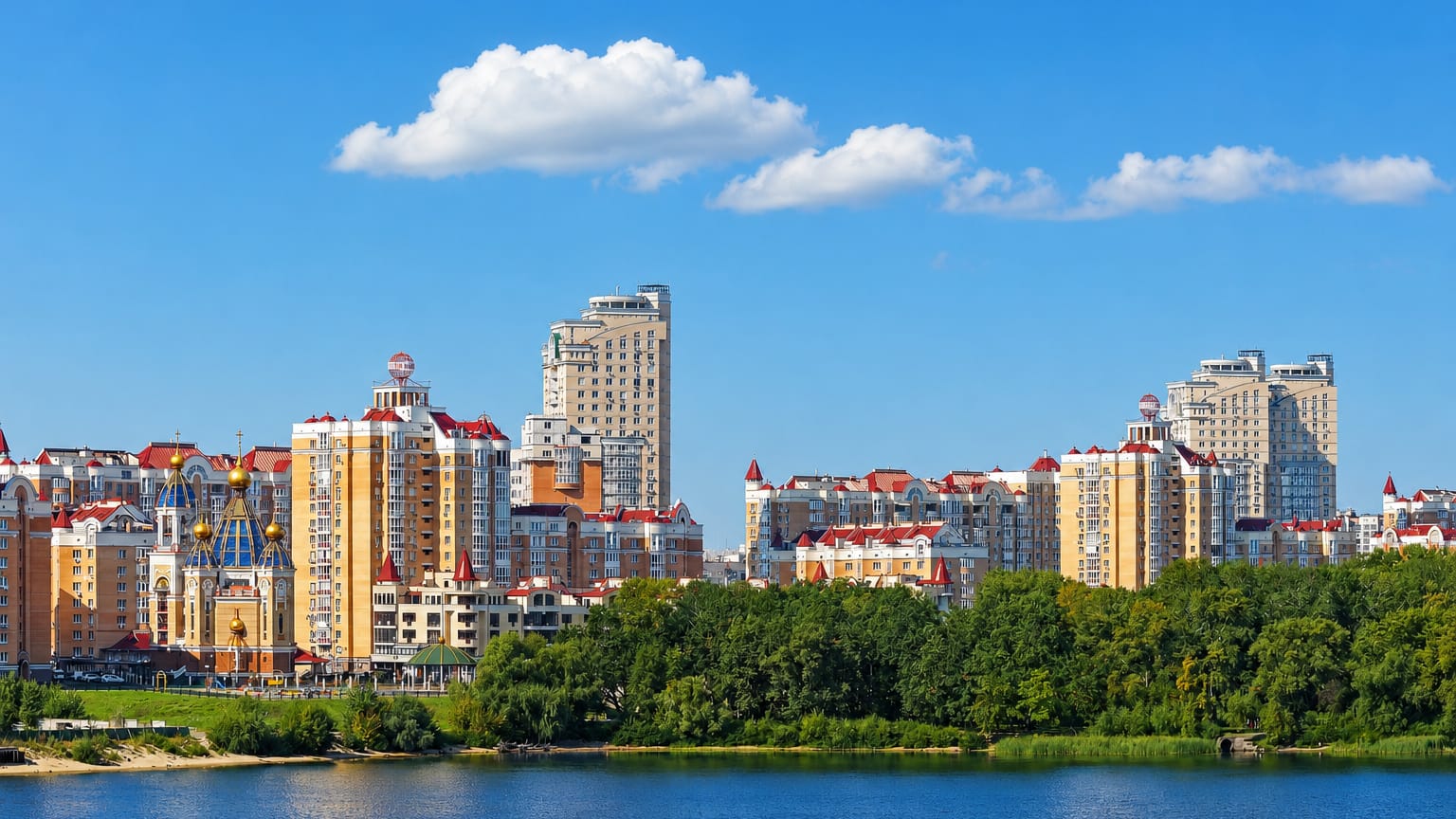 Obolon riverside skyline in Kyiv with a golden-domed church and pastel high-rises along the Dnieper