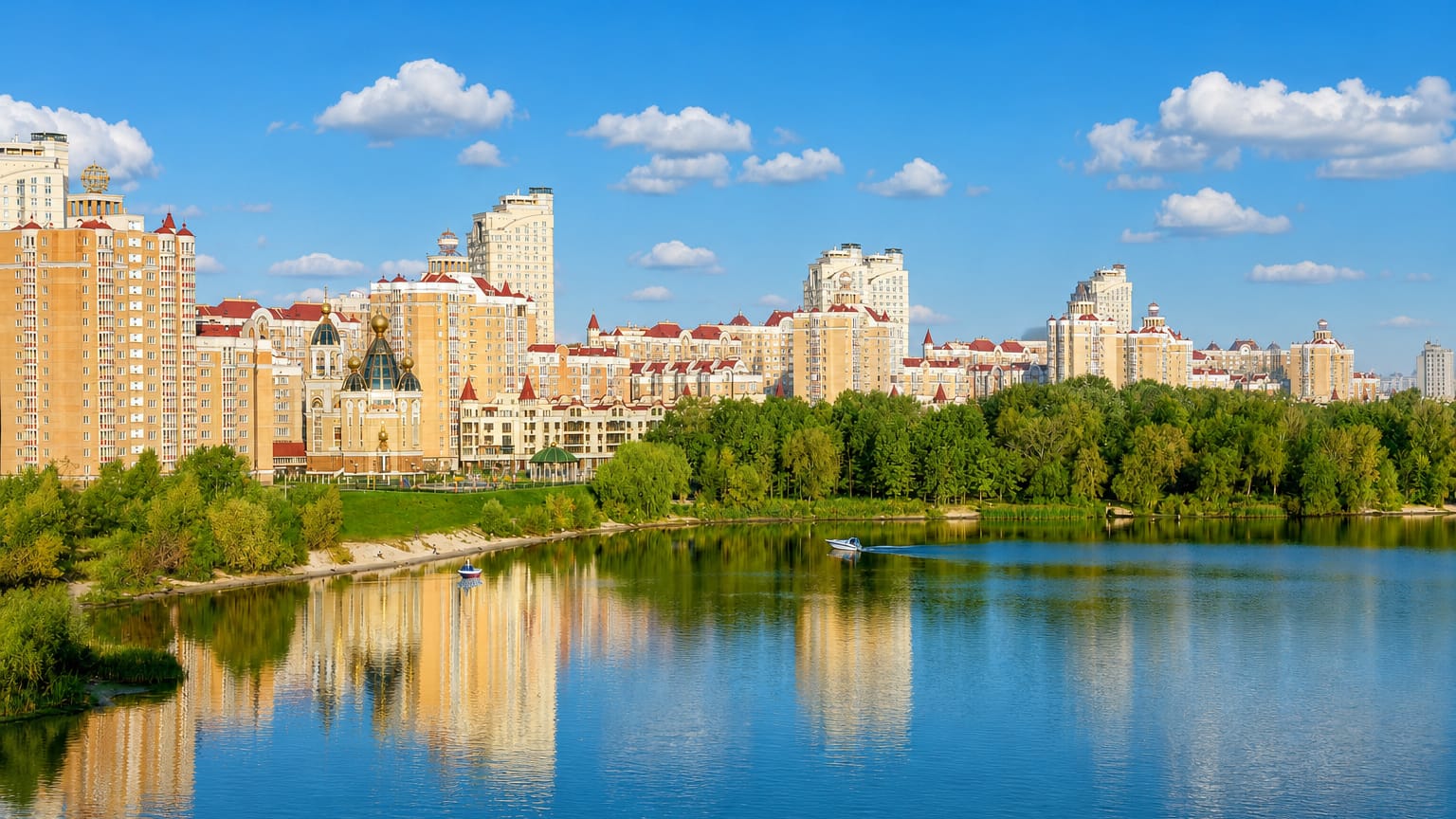 Golden-domed church and riverside apartment blocks of Kyiv's Obolon district reflected in the Dnipro.