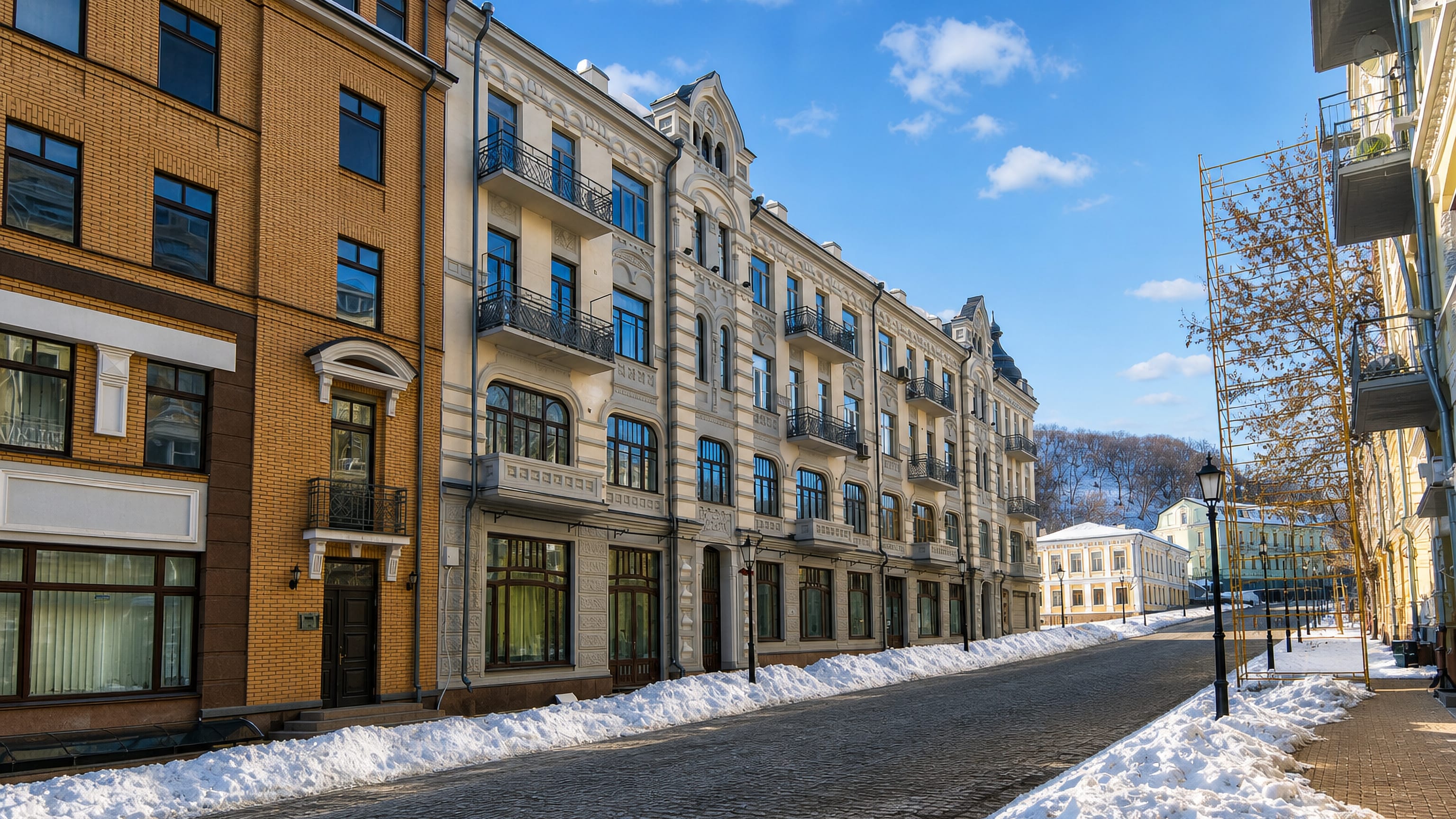 Snow lines a cobbled street of restored historic facades in Kyiv's Podil district.