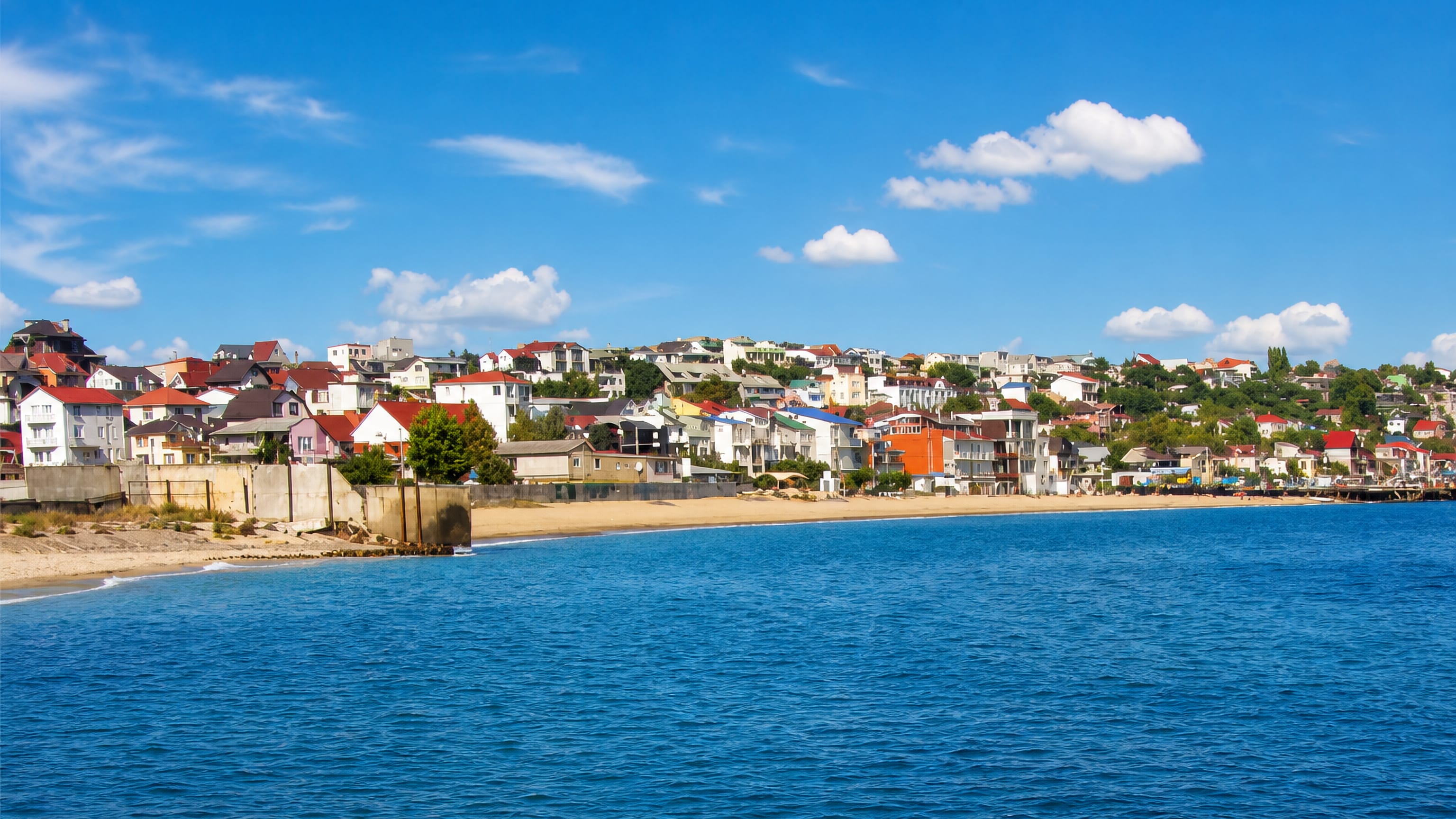 Sandy beach and hillside houses along the Black Sea shore at Chornomorsk, Ukraine.