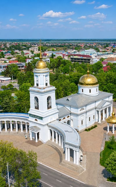 Aerial view of Izmail, Ukraine, centred on the white Intercession Cathedral with golden domes and its curved colonnade.