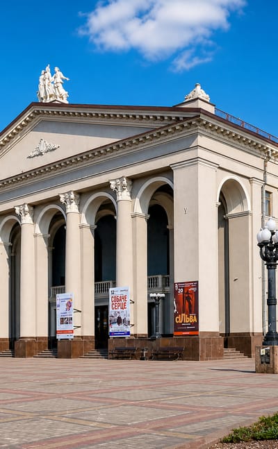 Neoclassical theatre on a paved square in Rivne, Ukraine, under a bright blue sky