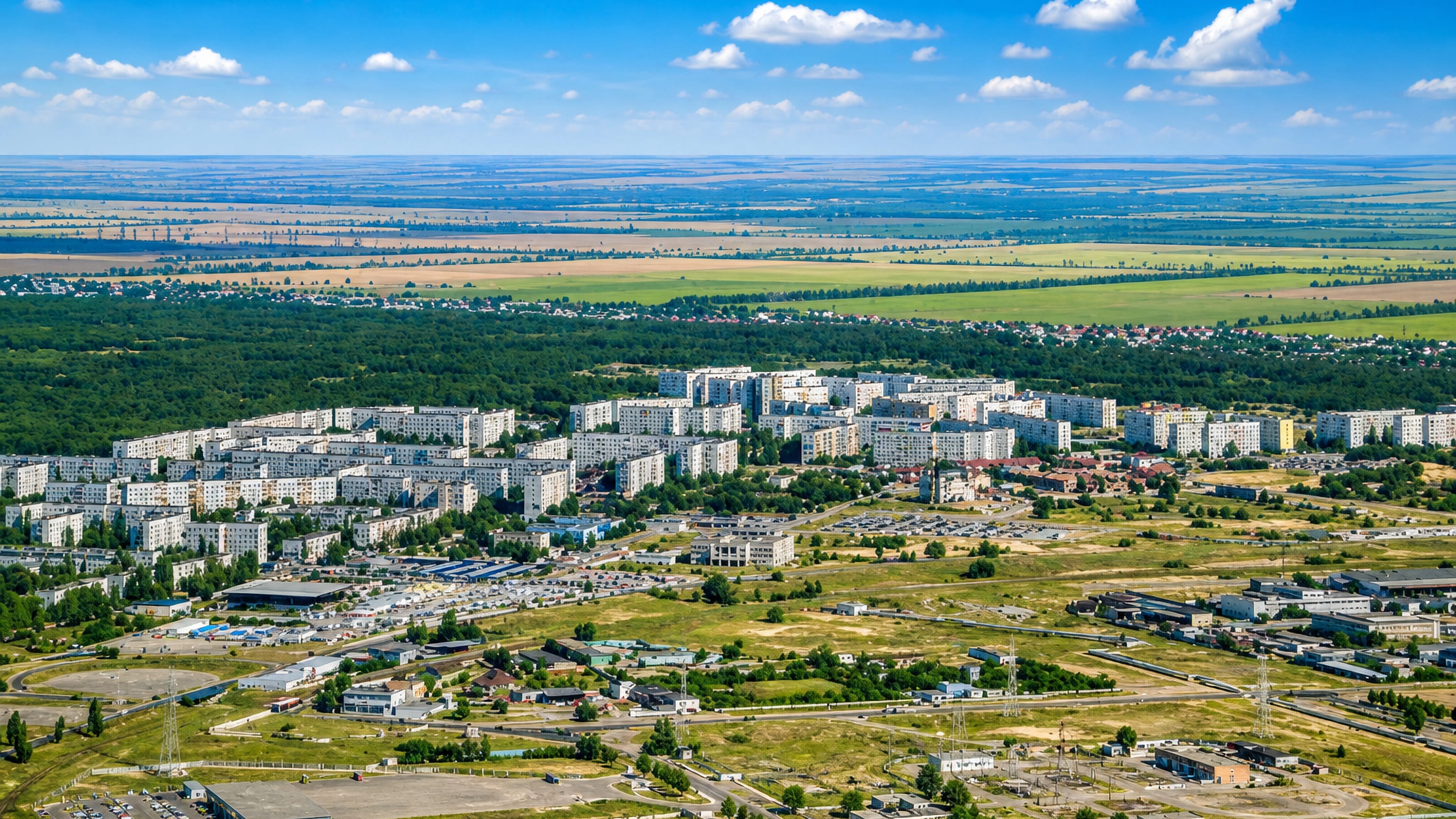 Aerial view of Enerhodar, Ukraine, with Soviet-era apartment blocks set among trees on flat green steppe.