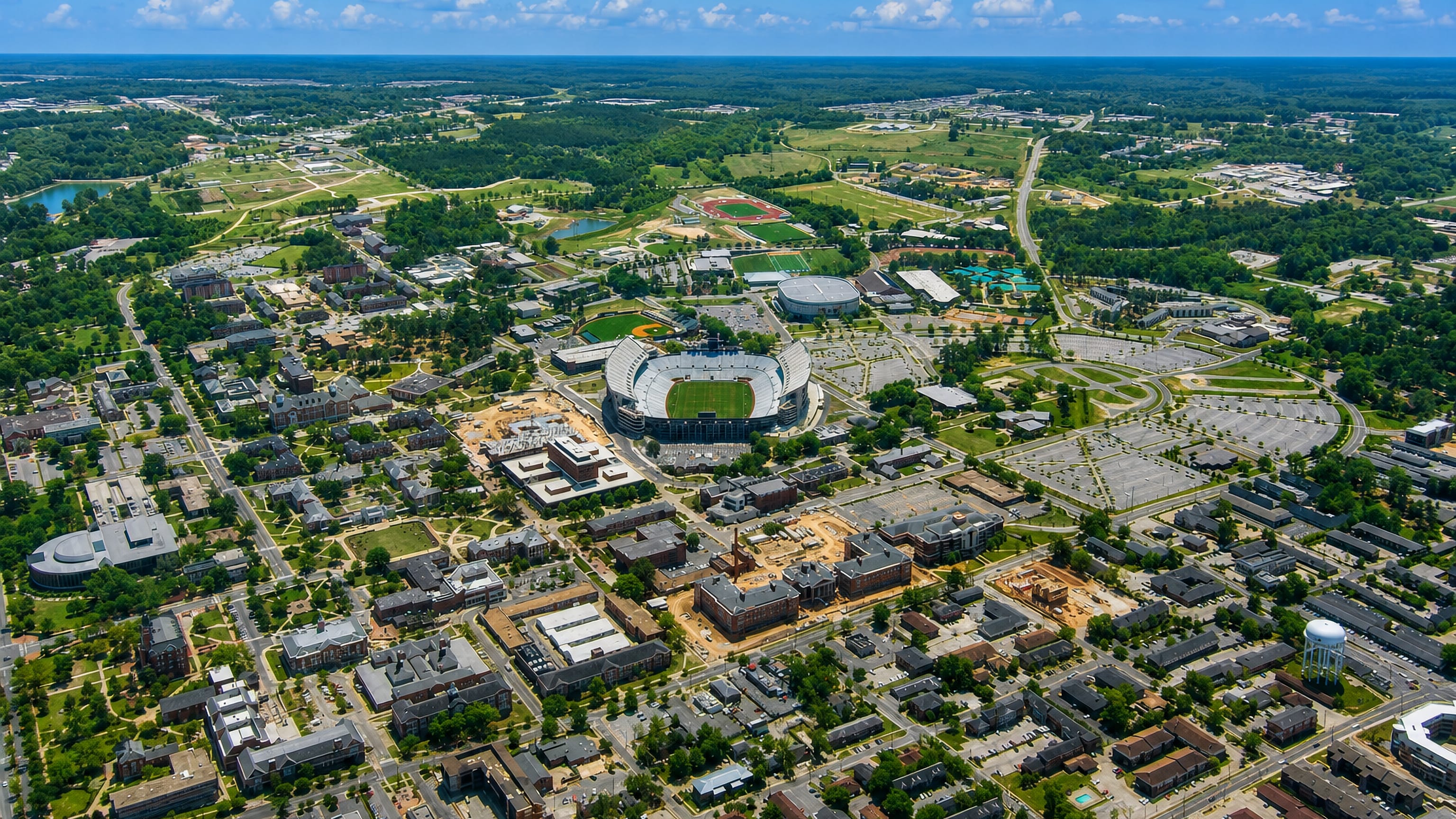 Aerial view of Auburn, Alabama, with its university campus, football stadium and arena ringed by pine woods.
