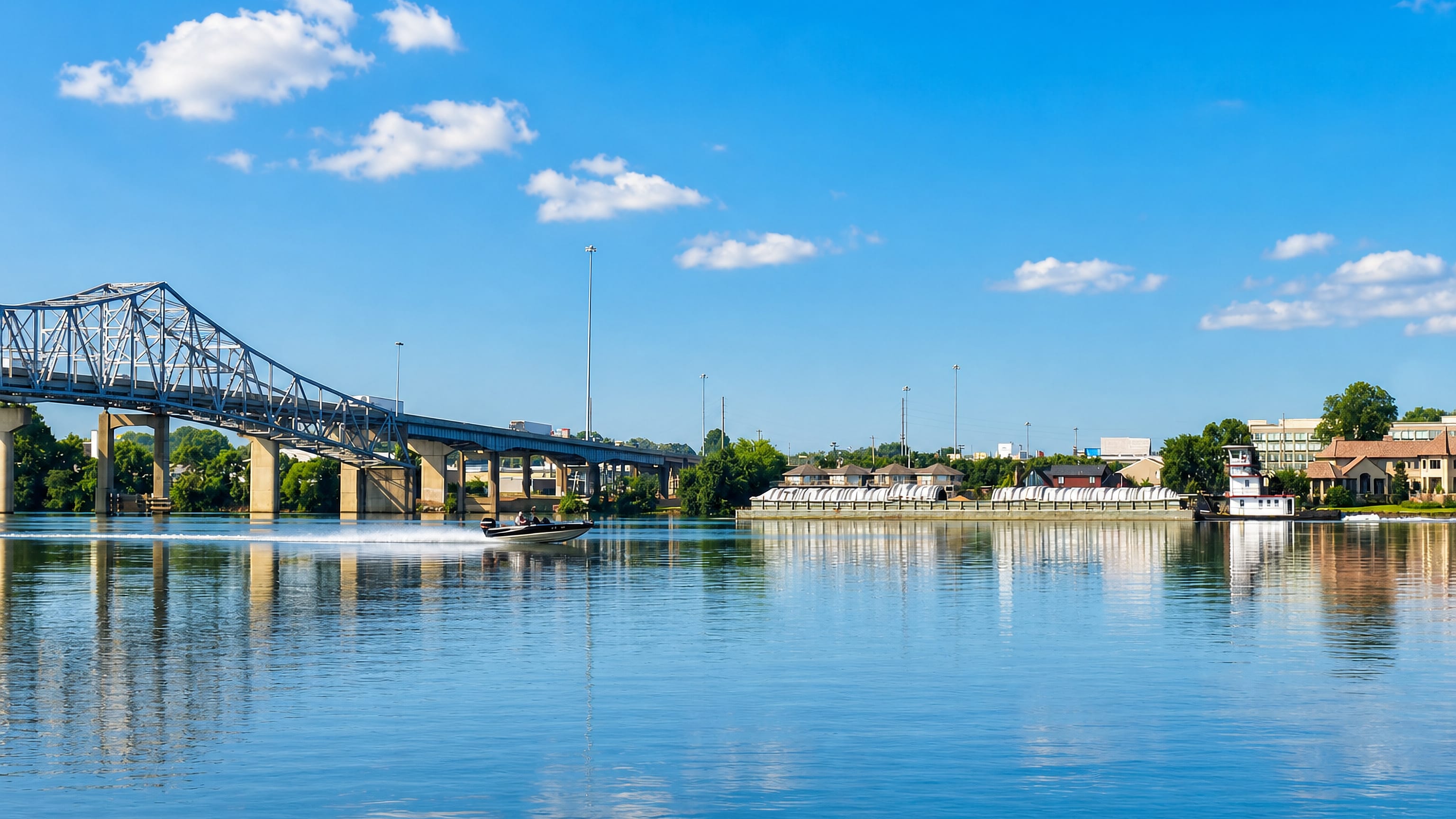 Steel truss bridge and a loaded barge tow on the Tennessee River at Decatur, Alabama.