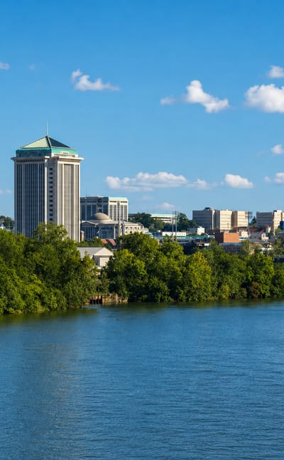 Montgomery, Alabama, skyline across the Alabama River with the RSA Tower and the domed State Capitol.