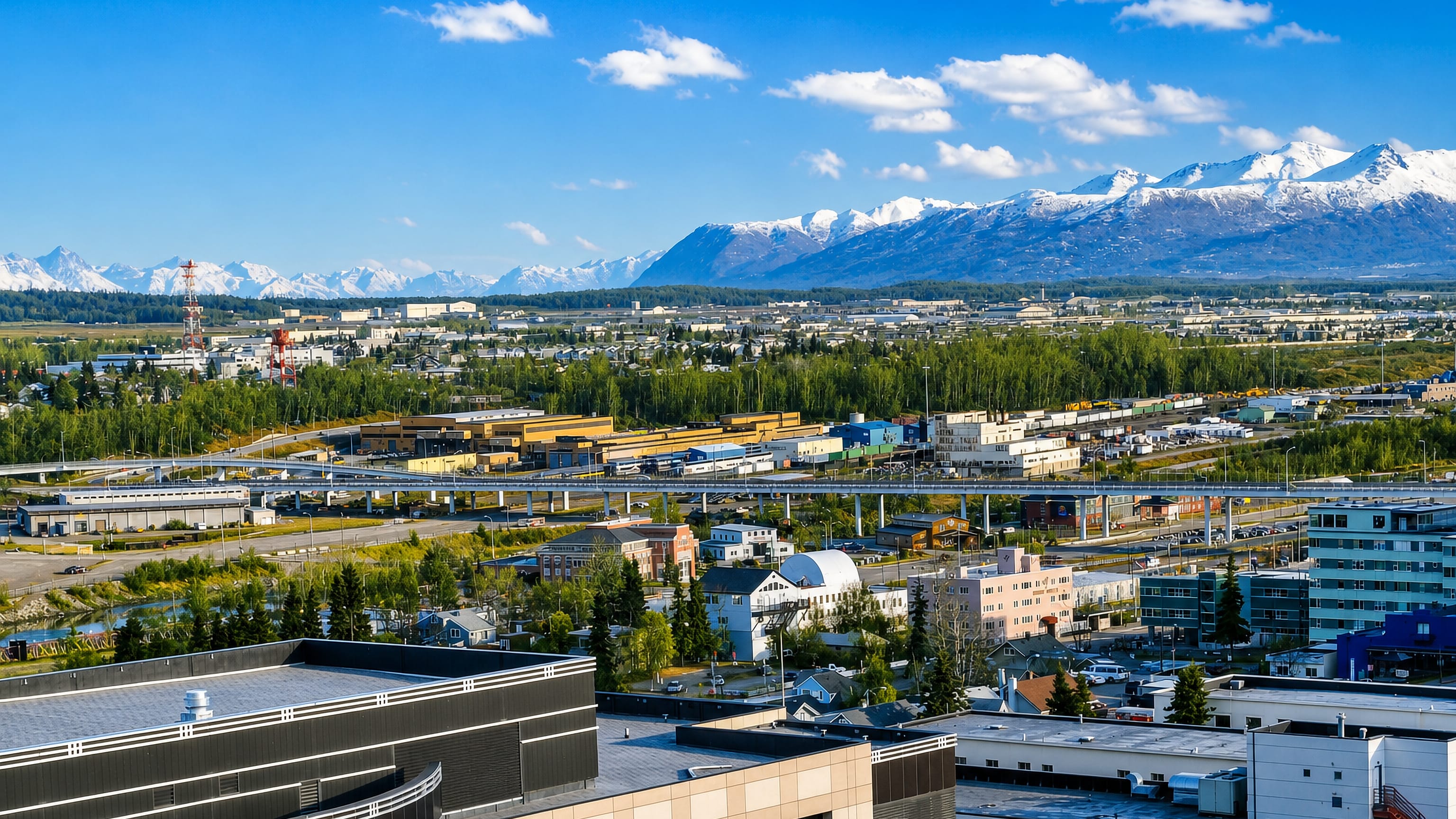 Anchorage rooftops, Ship Creek rail yards and the snow-capped Chugach Mountains seen from Government Hill.