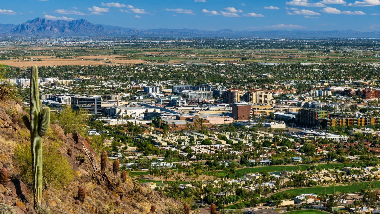 Scottsdale, Arizona spread across the Sonoran desert with a saguaro cactus and mountains beyond
