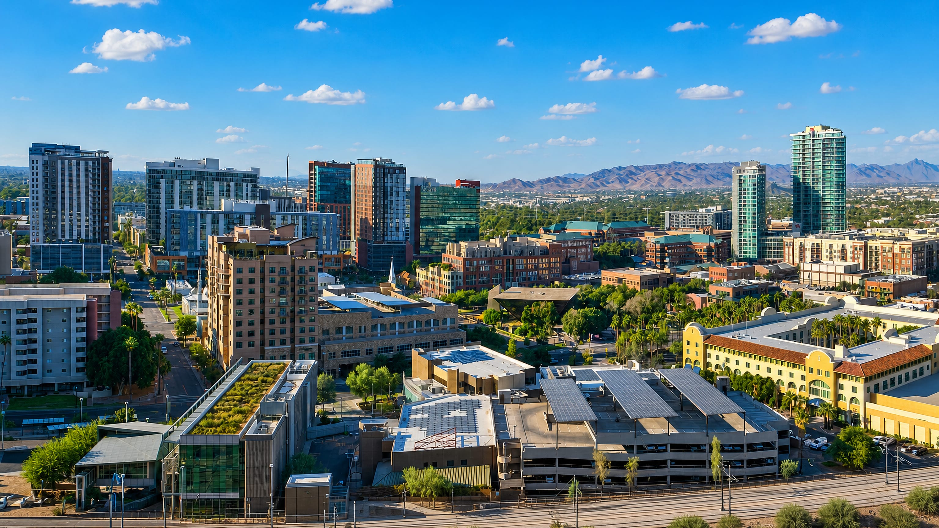 Downtown Tempe, Arizona, with glass mid-rise towers, palm-lined streets and desert mountains beyond.