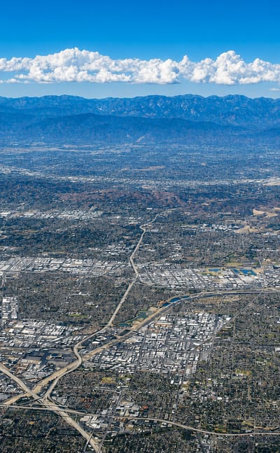 High aerial view of Southern California urban sprawl reaching toward the mountains around Anaheim.