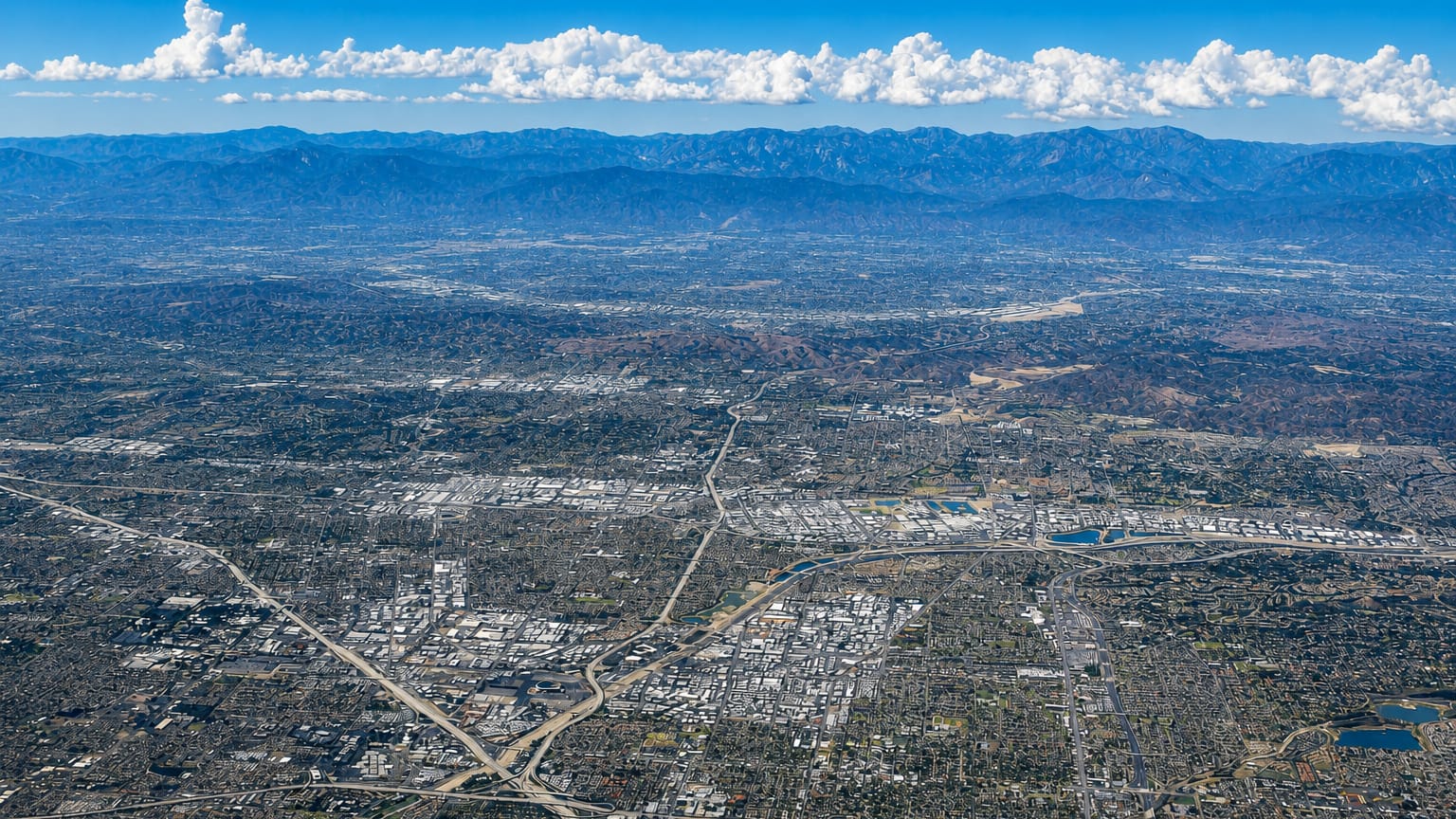 High aerial view of Southern California urban sprawl reaching toward the mountains around Anaheim.