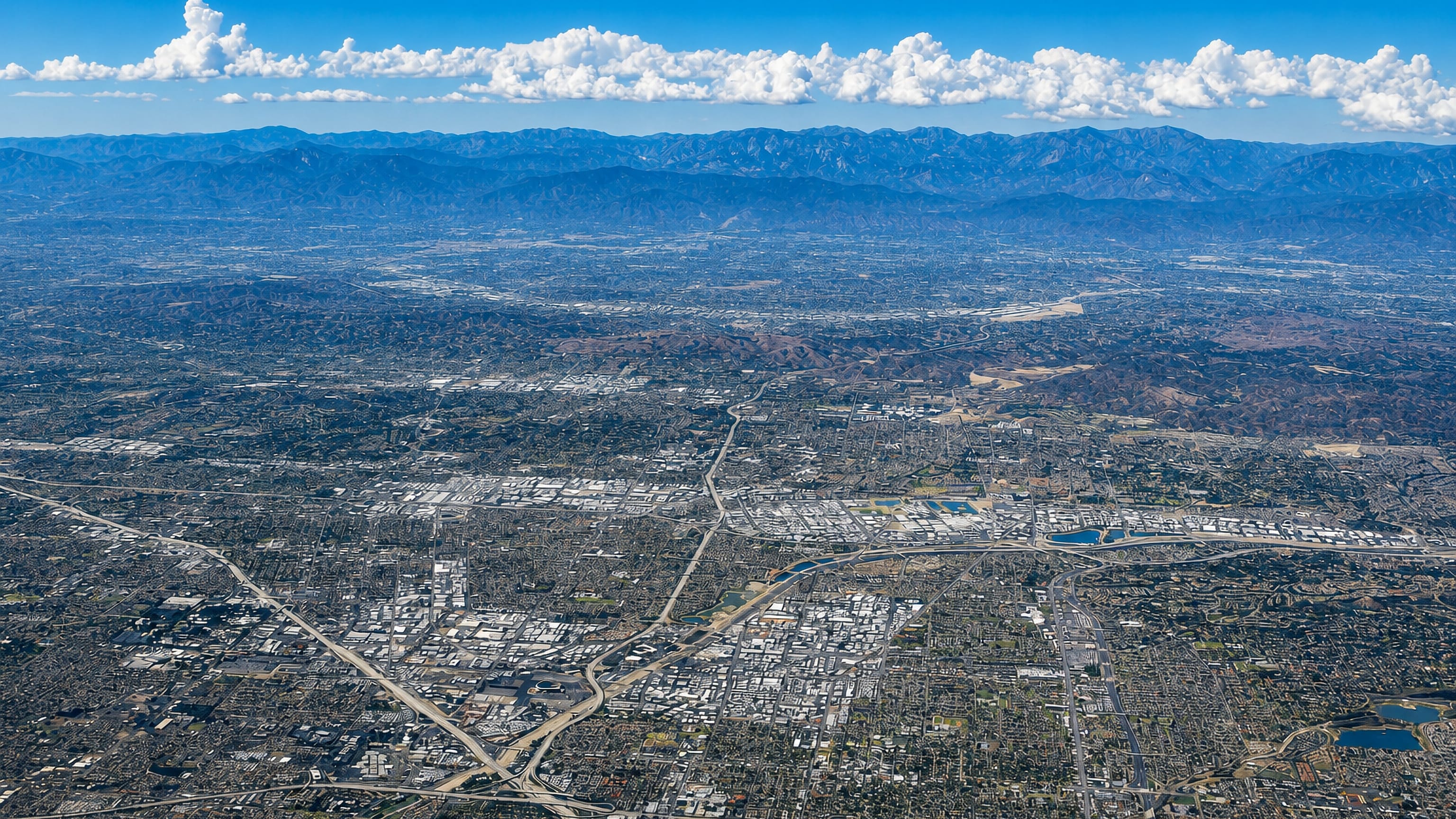 High aerial view of Southern California urban sprawl reaching toward the mountains around Anaheim.