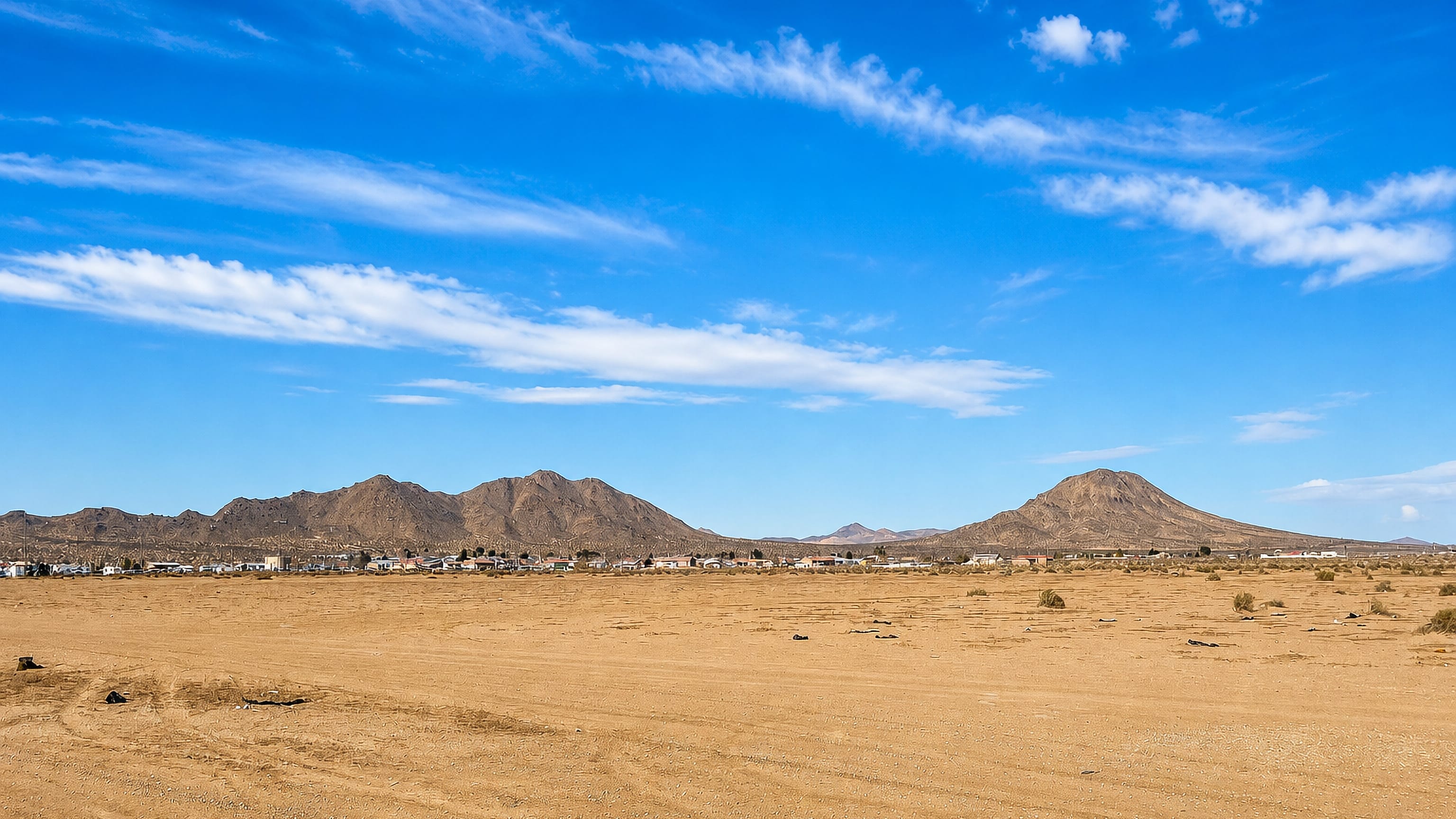 Apple Valley, California, spread along the Mojave Desert floor beneath bare granite hills under a clear blue sky