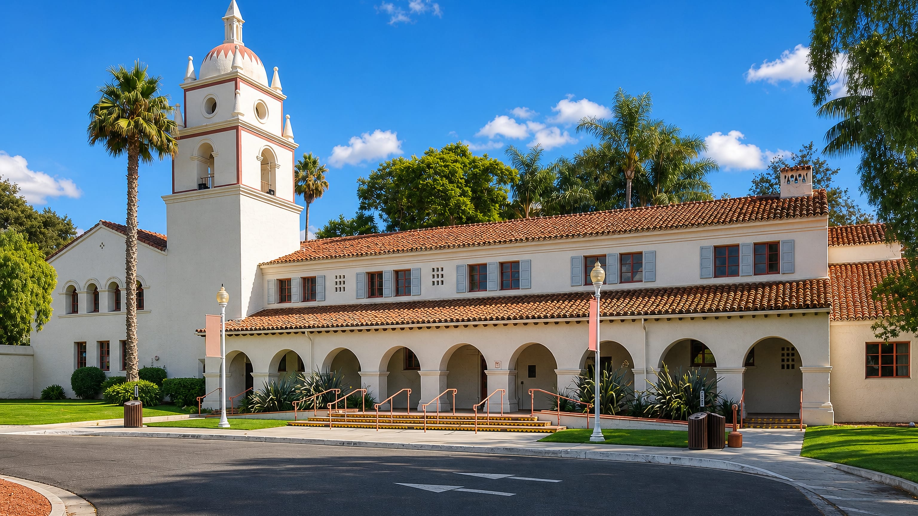 Mission Revival bell tower and arcaded wing among palms in Camarillo, California