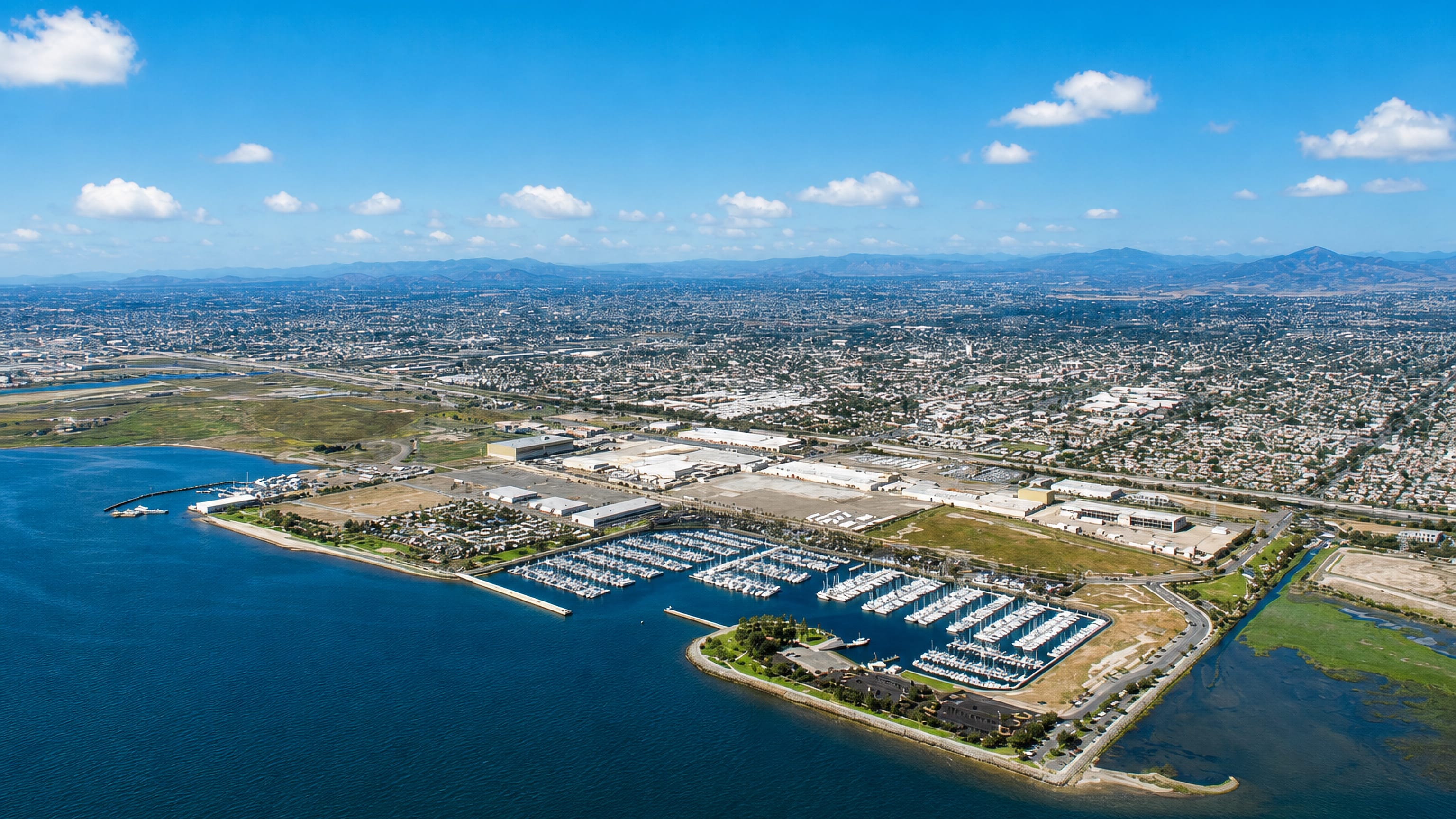 Aerial view of Chula Vista, California, its bayfront marina on San Diego Bay backed by suburbs and distant hills.