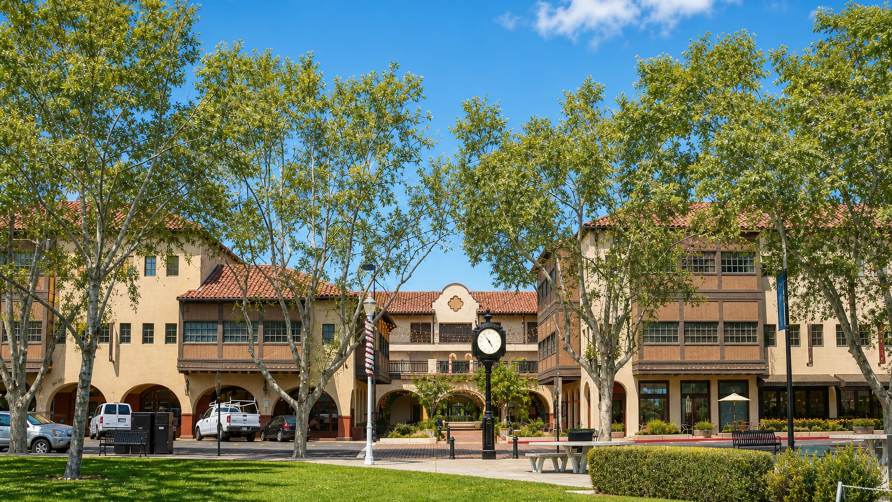 Mission-style arcaded storefronts and a street clock around the downtown plaza in Concord, California.