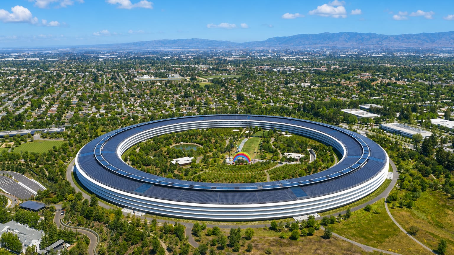 Cupertino, California with Apple Park's circular headquarters amid Silicon Valley greenery and mountains