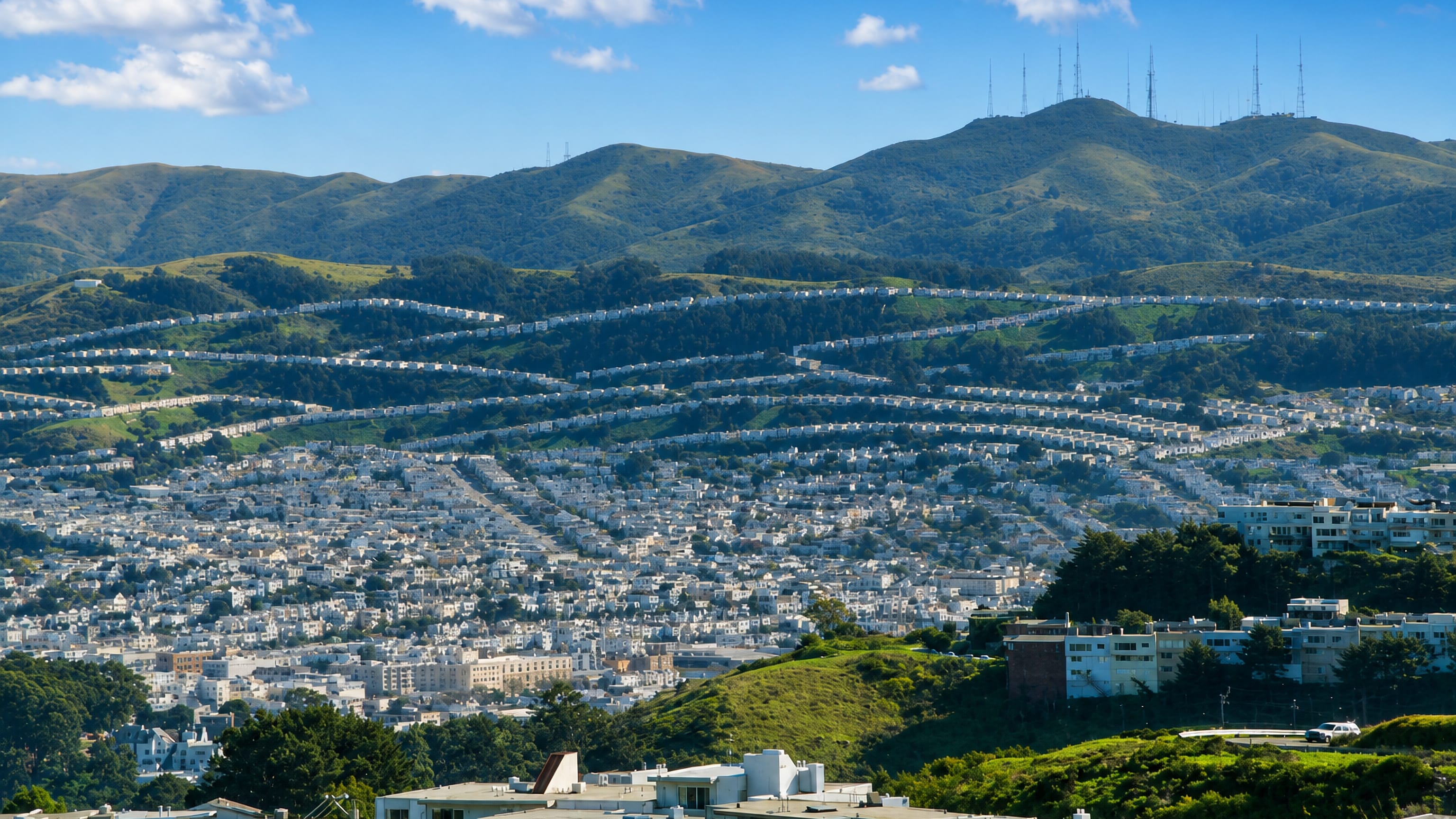Rows of pastel tract houses climbing the San Bruno Mountain ridges above Daly City, California.