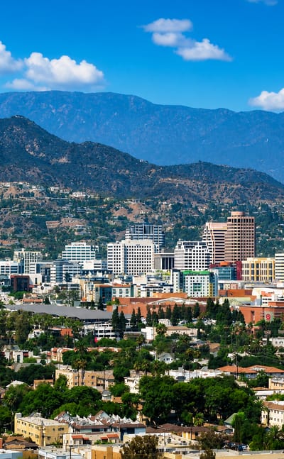 Downtown Glendale, California mid-rise skyline backed by the Verdugo Mountains under a clear sky