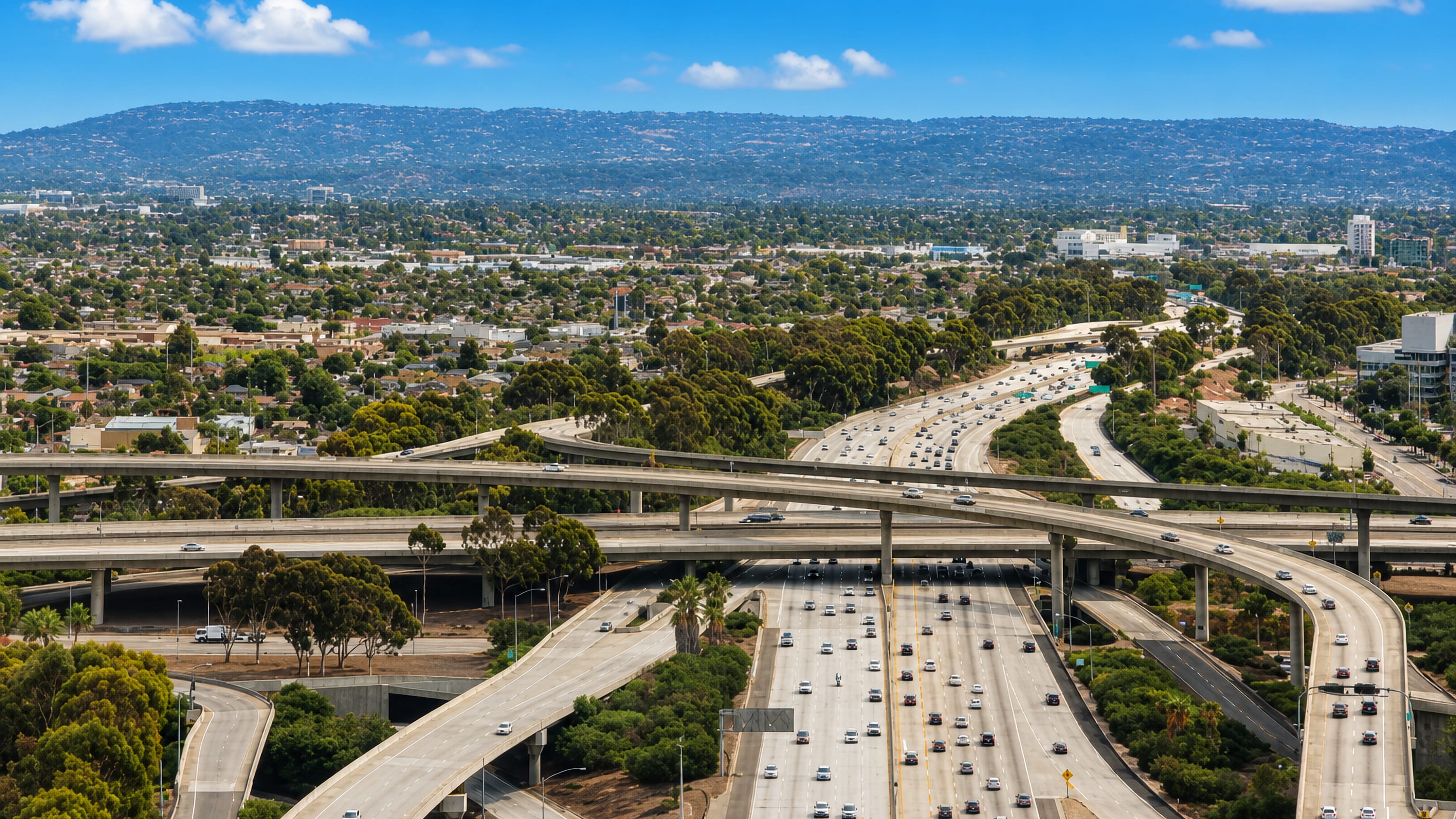 Aerial view over Hawthorne, California, where multi-level freeway interchanges cut through the Los Angeles basin.