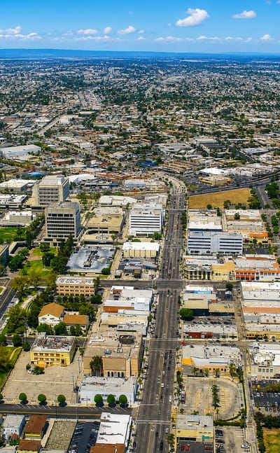Aerial view over Inglewood, California, its low-rise grid stretching toward the horizon on a clear day