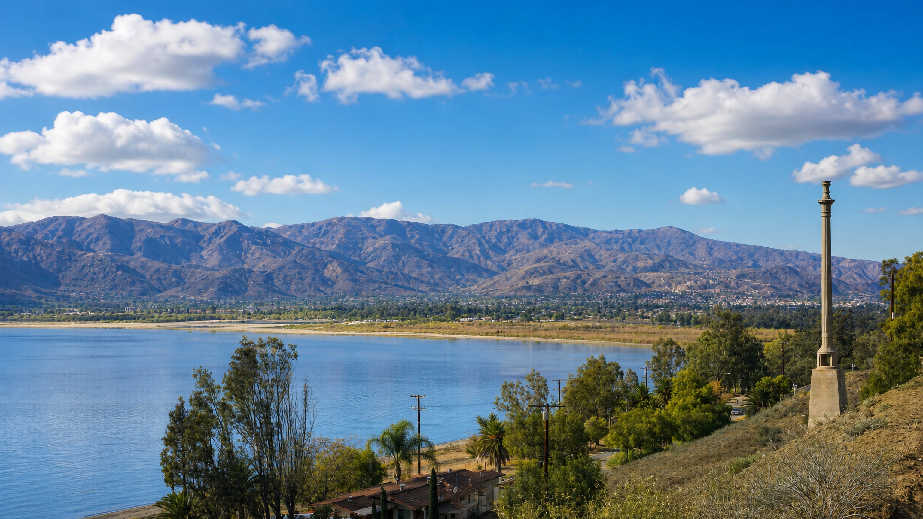 Lake Elsinore's blue lake and lakeside homes below the Santa Ana Mountains in Southern California.