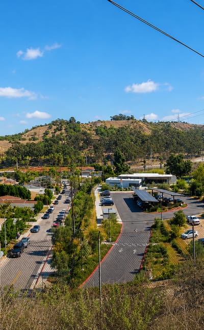 Hillside residential streets and a business lot in Culver City with the distant Los Angeles skyline