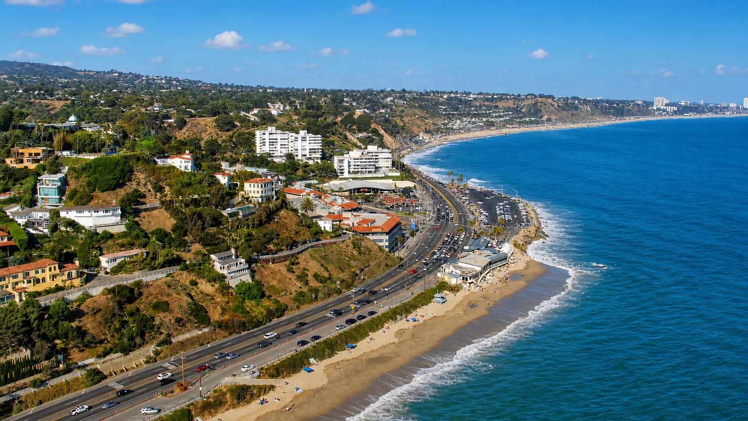 Coastal bluffs and beach along Pacific Coast Highway at Pacific Palisades, with the ocean and Santa Monica beyond