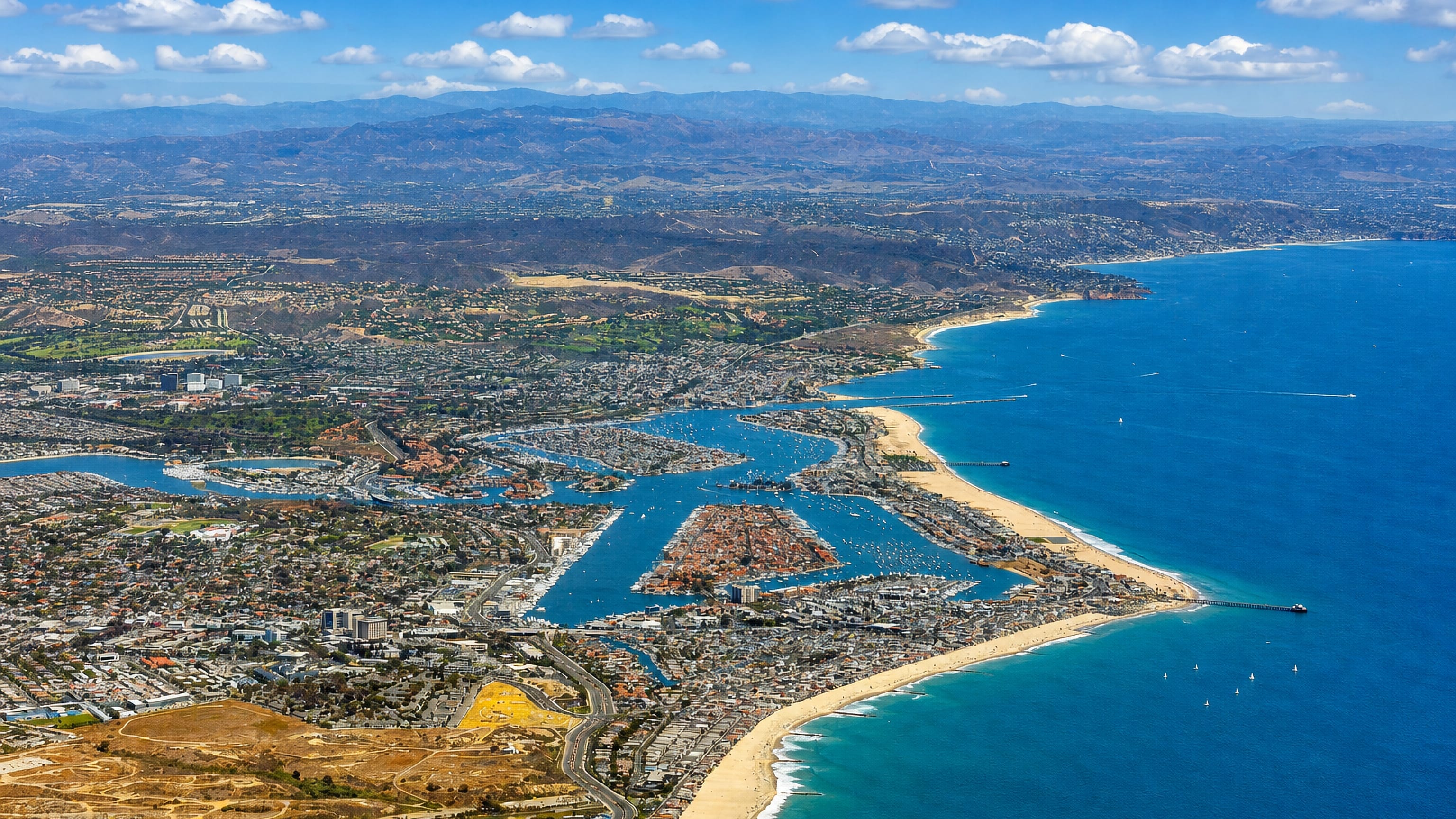 Aerial view of Newport Beach, California, with Newport Harbor, Balboa Peninsula and its piers along the Pacific coast.
