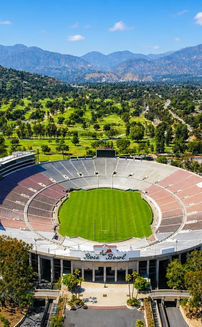 Aerial of Pasadena's Rose Bowl stadium backed by the San Gabriel Mountains