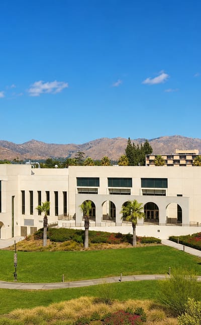 A Mission Revival-style civic building with palms and mountains in Riverside, California