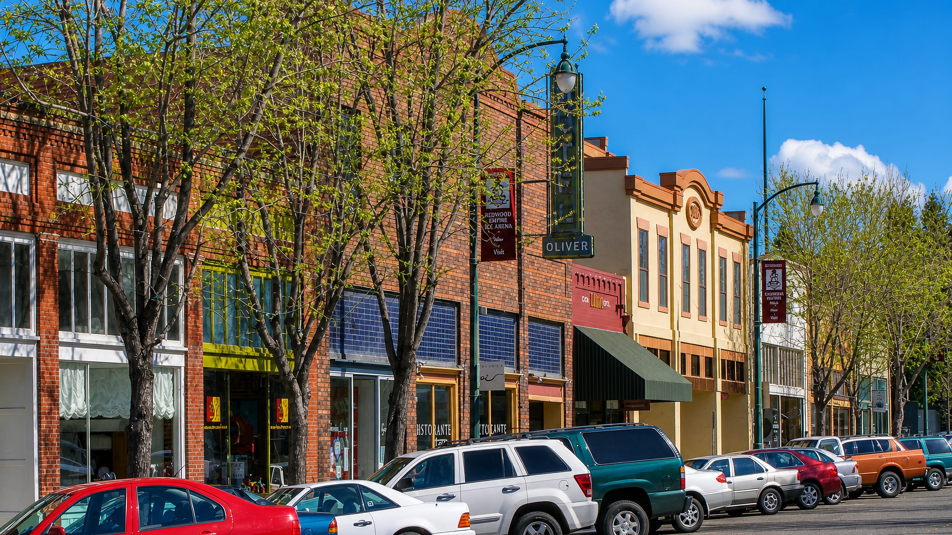 Downtown Santa Rosa street of brick storefronts with a Redwood Empire Ice Arena banner and parked cars