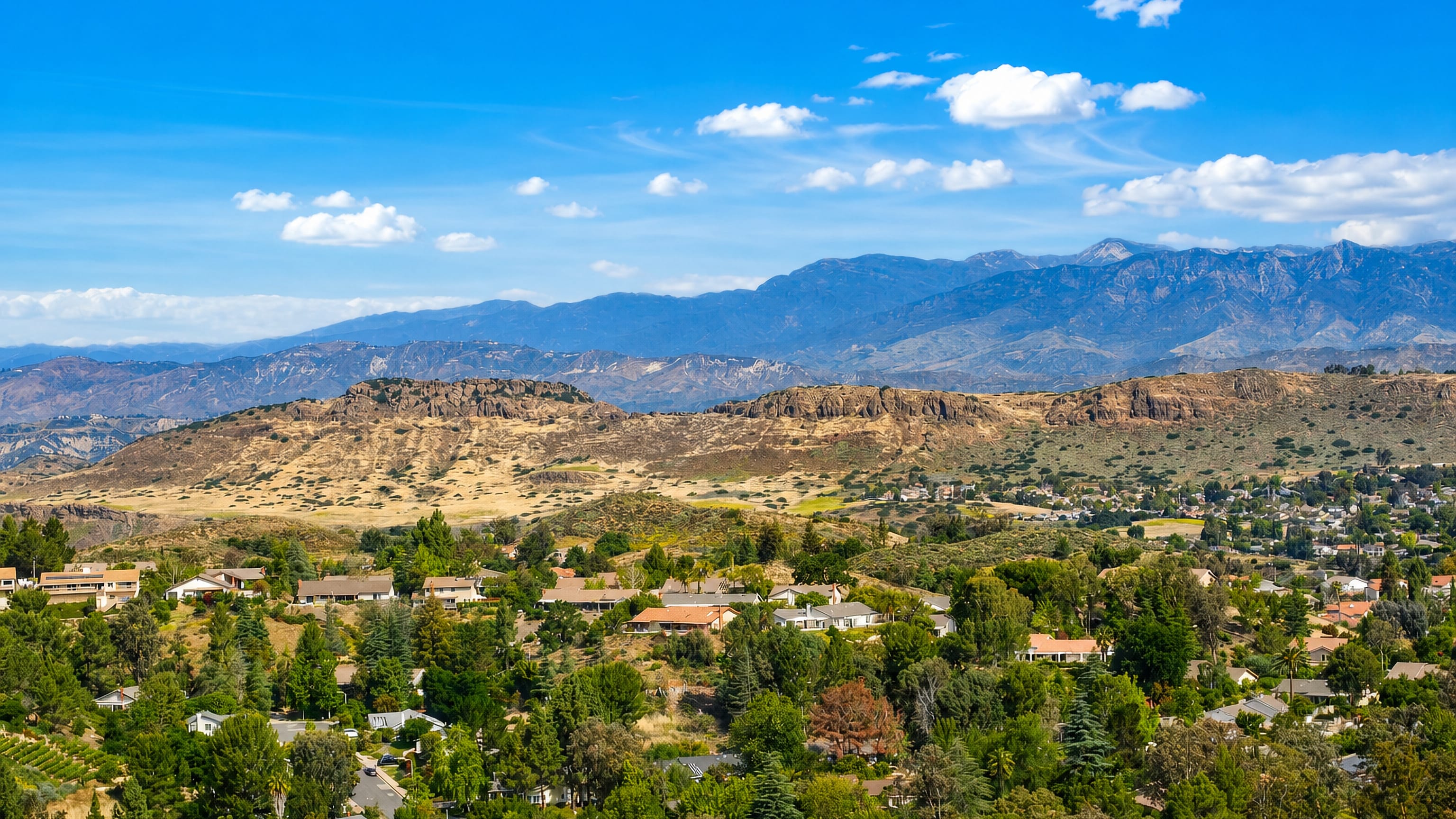 Thousand Oaks homes set among oak groves in the Conejo Valley, with rocky ridges and mountains behind.