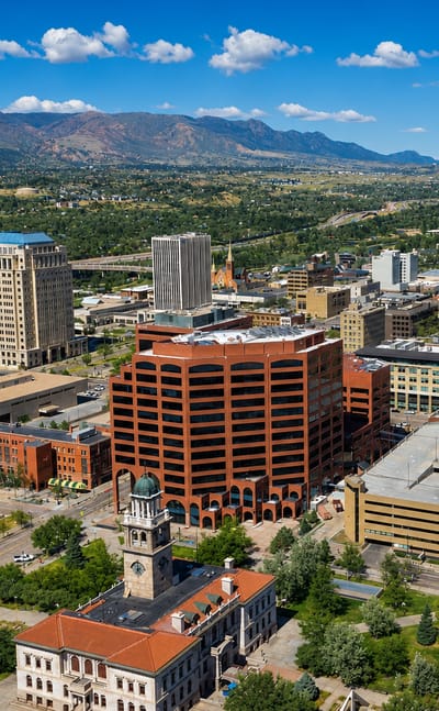 Aerial view of downtown Colorado Springs with its historic clock tower and the Front Range beyond