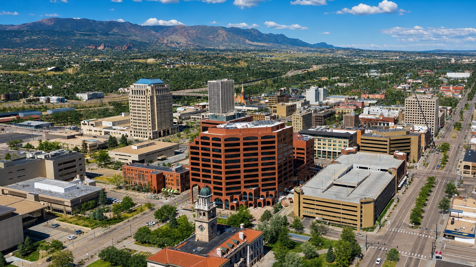 Aerial view of downtown Colorado Springs with its historic clock tower and the Front Range beyond