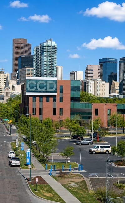 Downtown Denver skyline rising behind the red-brick Community College of Denver campus in the Auraria neighborhood.
