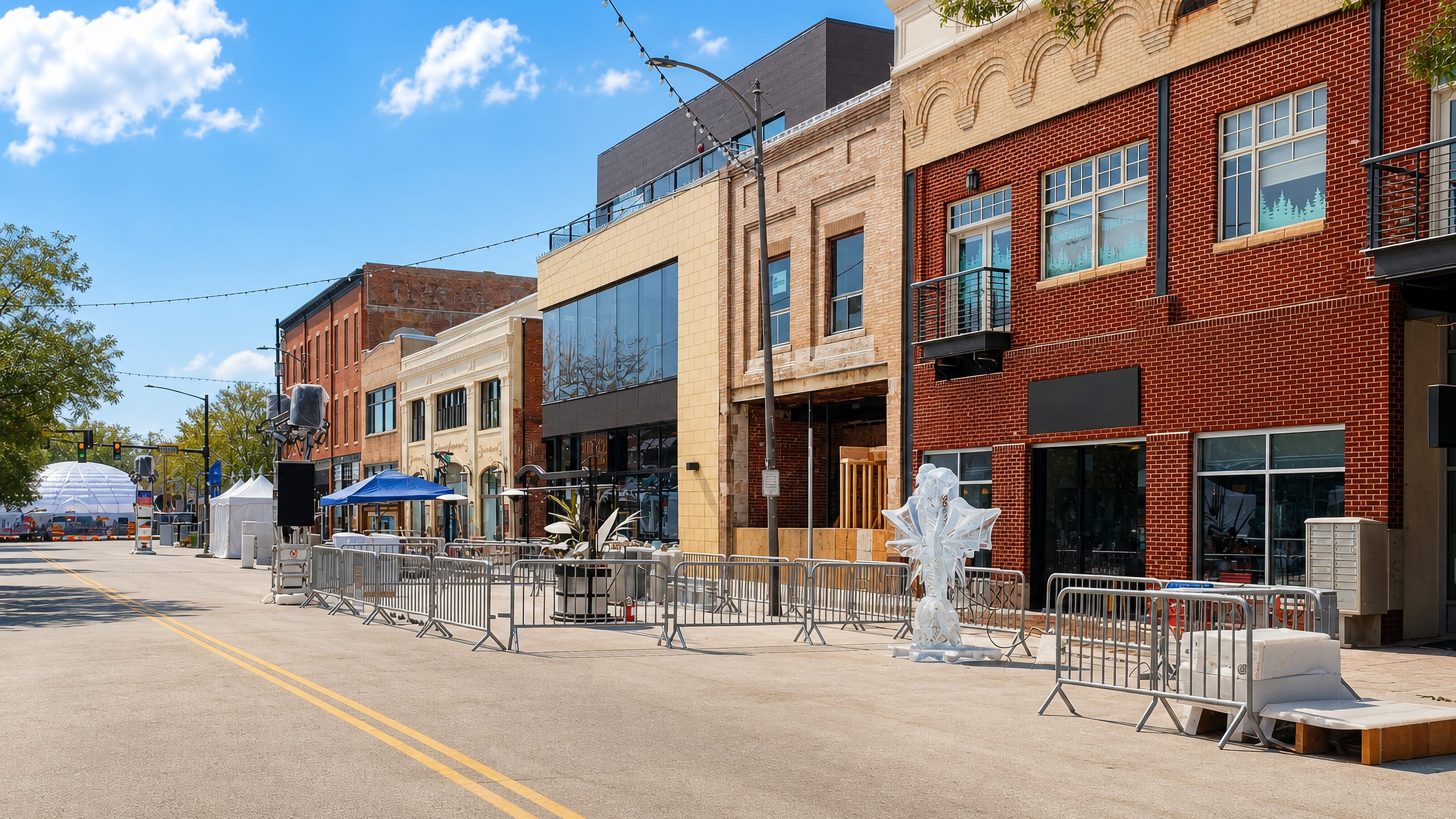Downtown Loveland, Colorado: brick and stone storefronts along a sunlit main street with event barriers at the curb.