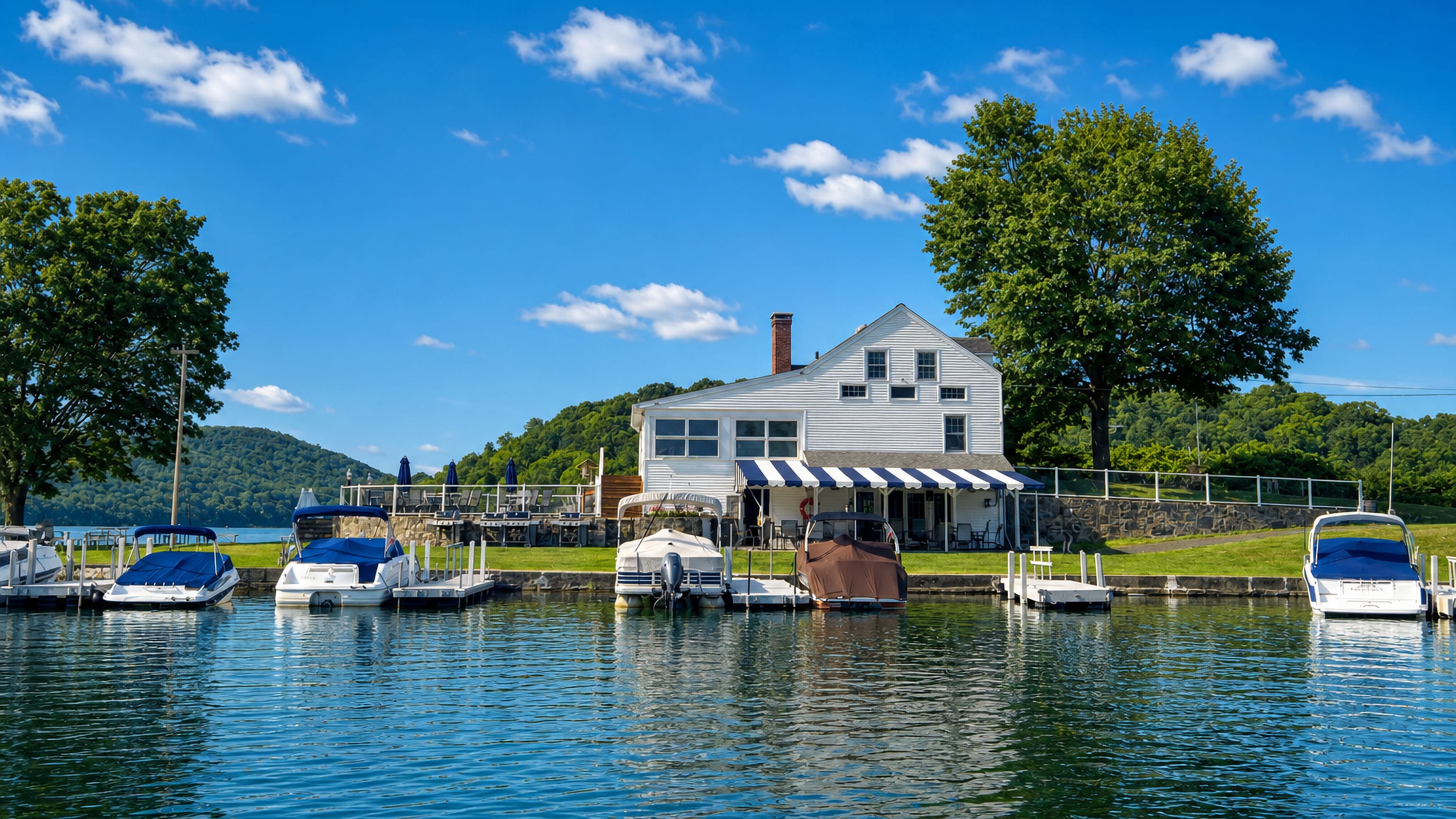 White clapboard lakeside marina building and moored boats on a wooded lake near Danbury, Connecticut.