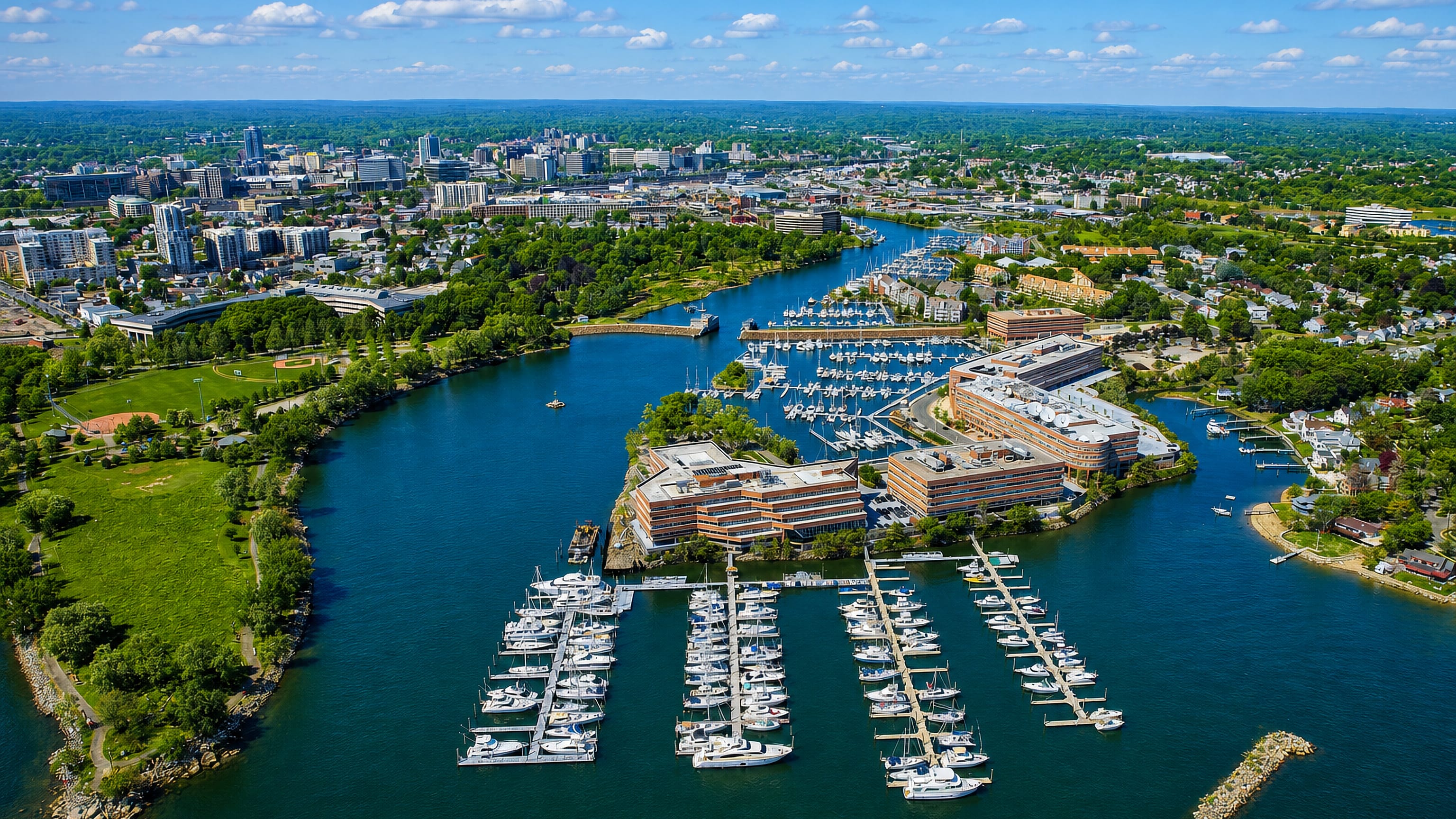 Aerial view of Stamford Harbor, Connecticut, with marina docks, waterfront offices and the downtown skyline.