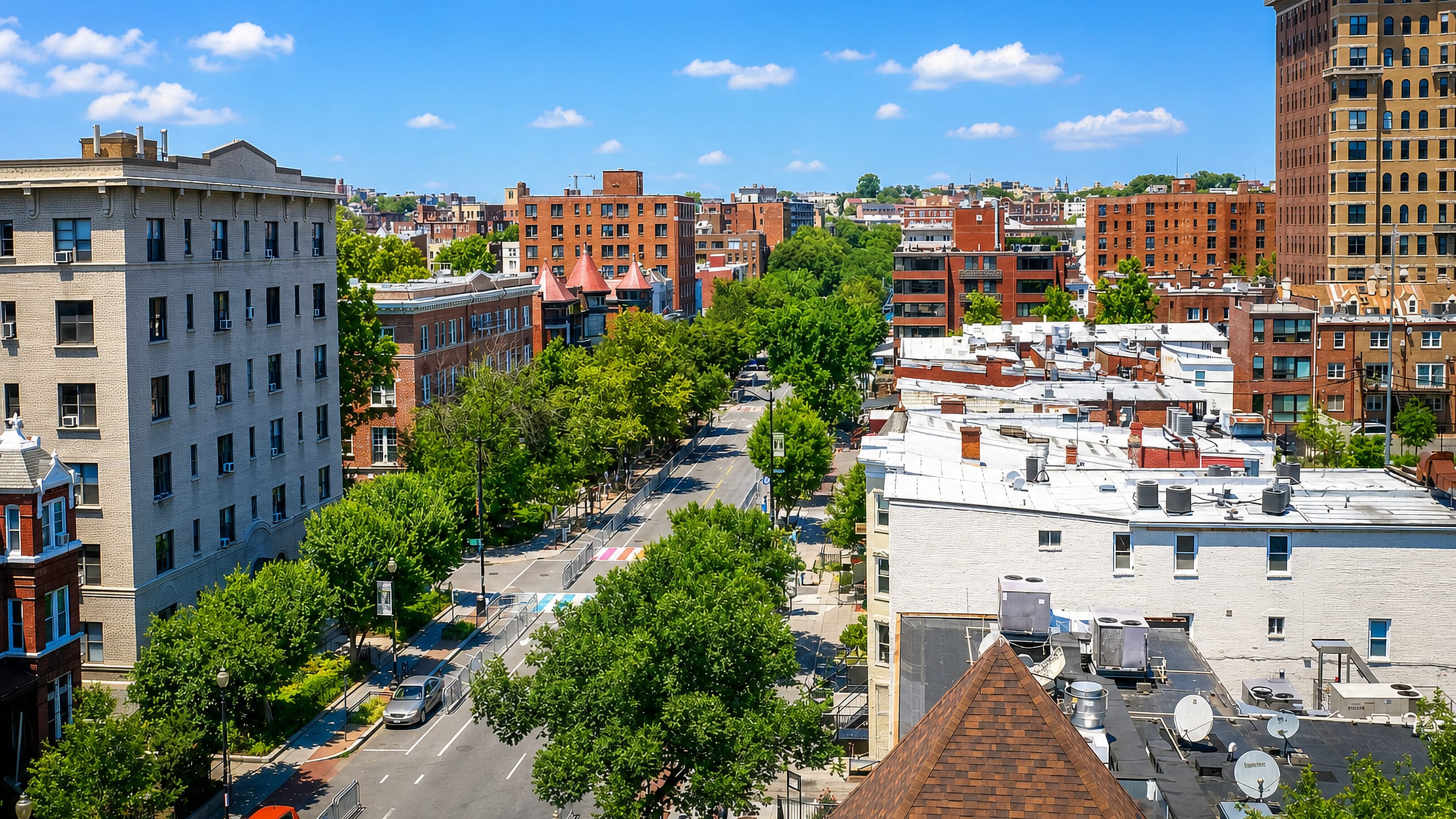 Tree-lined avenue and brick rowhouse blocks seen from above in the Dupont Circle area of Washington, DC.