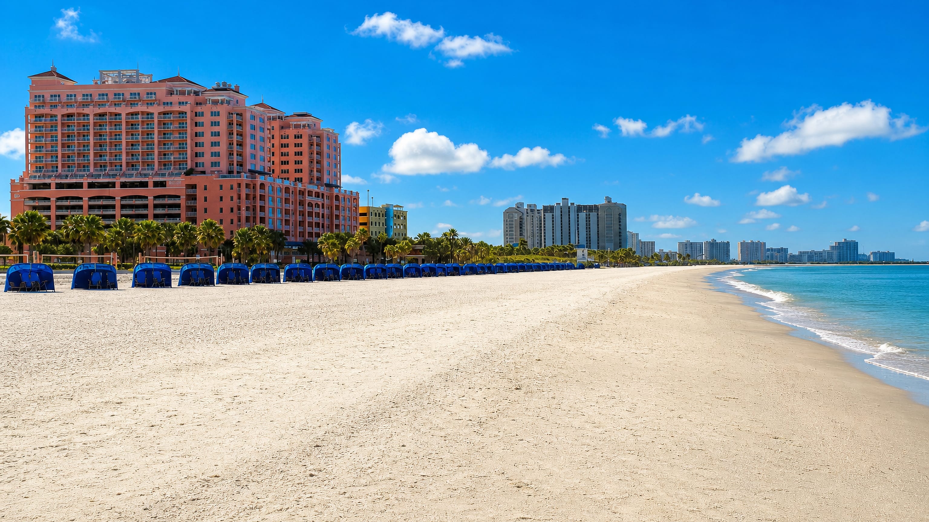 Clearwater Beach's white sand, blue cabanas and turquoise Gulf water fronting a pink resort and condo towers.